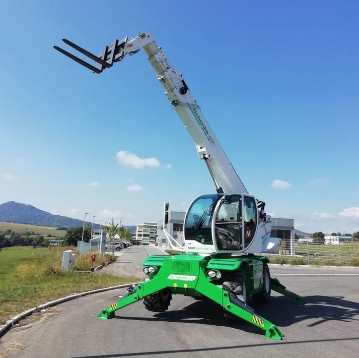 Baumaschinen mieten - Weisser Teleskoplader mit grünen Stützen